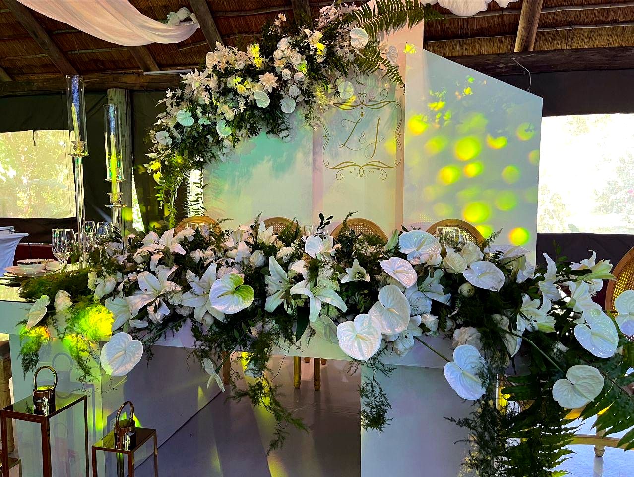 Arco floral branco com folhagem, montado num evento em Moçambique