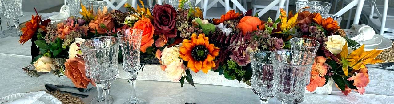 Arranjo floral de mesa em tons de outono: rosas, girassóis e folhagem
