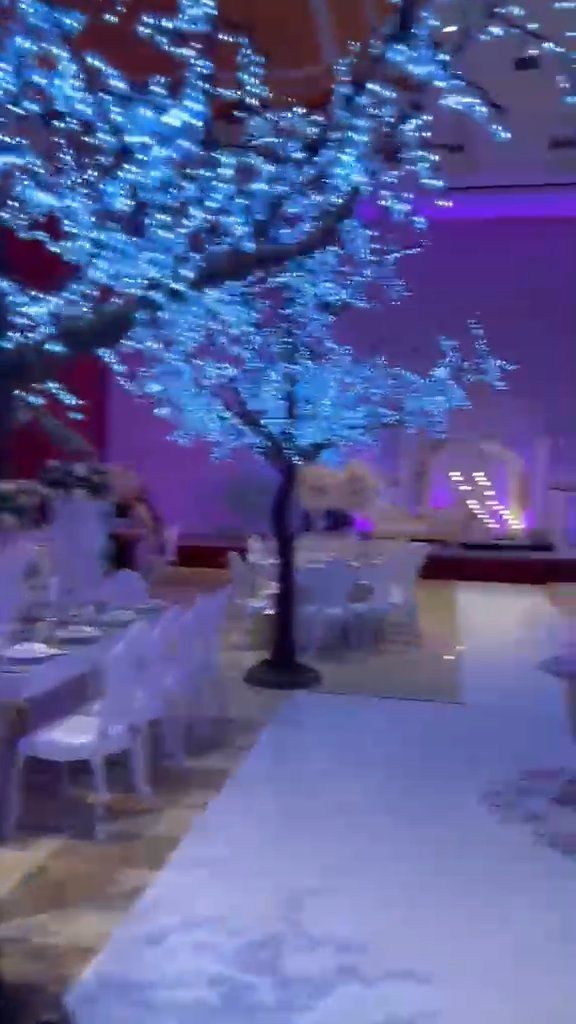 Salão de gala com árvore de luz azul e mesas postas
