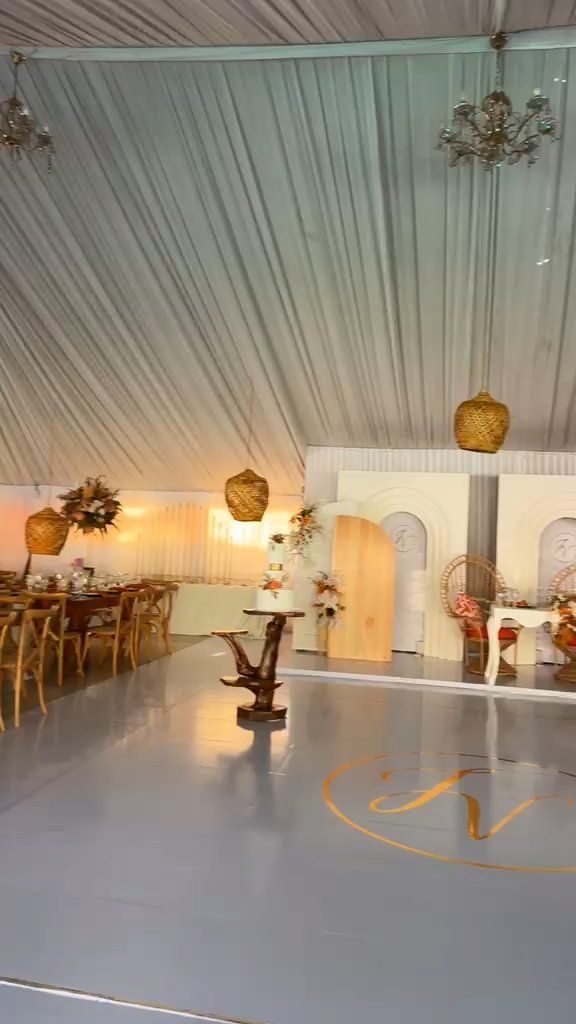Tenda de gala com mesas de madeira, candeeiros de vime e pista de dança